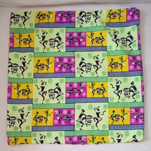 Puede incluir: Tela cuadrada con un patrón repetido de bailarines y tambores en una cuadrícula. La cuadrícula presenta cuadrados alternos de verde claro, amarillo y morado, con los bailarines en negro y verde. La tela tiene un fondo blanco.