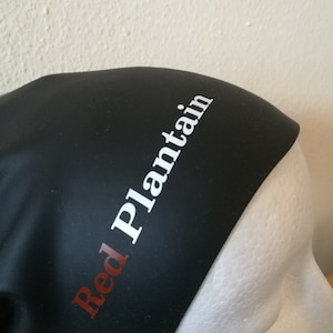 May include: Black silicone swim cap with the text "Red Plantain" in white letters.