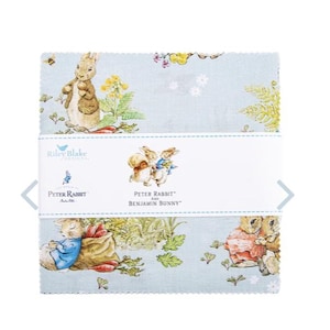 以下が含まれることがあります： 薄い青色の背景に、ピーターラビットとベンジャミンバニーのイラストが描かれた生地の正方形の束。生地には、花や葉とともにキャラクターが繰り返されるパターンがあります。製品には「Peter Rabbit Benjamin Bunny」と表示されています。