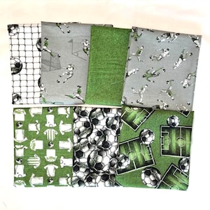 May include: A collection of soccer-themed fabric squares. Patterns include soccer balls, soccer nets, soccer players, and soccer fields in shades of green, gray, and white. The fabric is likely cotton or a similar material.