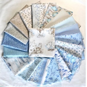 May include: A collection of fabric swatches in various shades of blue, beige, and white. Patterns include seashells, fish, stripes, and coastal scenes with dogs and seagulls. The fabrics are arranged in a circular pattern.