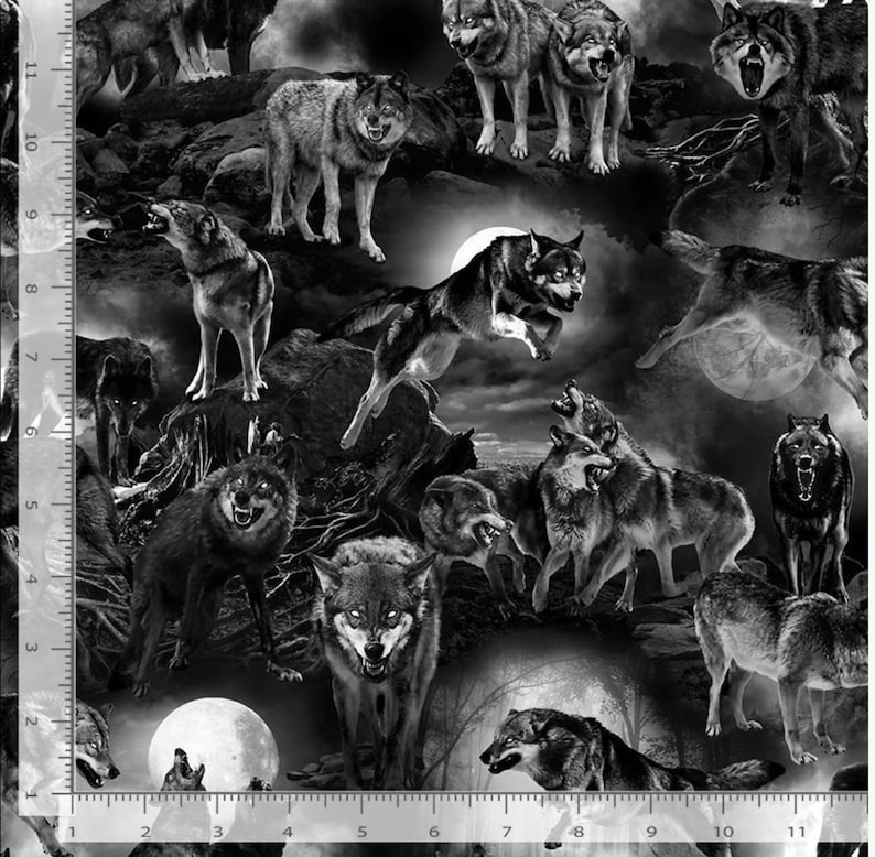 May include: A black and white fabric print featuring multiple wolves in various poses, including running, standing, and howling against a moonlit landscape. A vertical ruler on the left side shows measurements in inches from 0 to 11 inches.