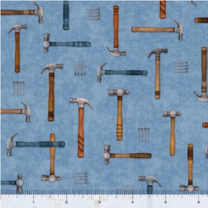 May include: A blue fabric with a repeating pattern of hammers and nails. The hammers are in various styles, including claw hammers and ball-peen hammers. The nails are in groups of three.