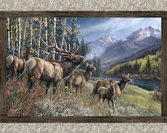May include: A framed print depicts a herd of elk in a mountain landscape. The elk, with their brown fur and large antlers, stand in a field of wildflowers near a river. The background features a forest, mountains, and a cloudy sky.