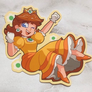 May include: A cartoon illustration of Princess Daisy from the Super Mario franchise. She is wearing a yellow dress with a green gem, a crown, and white gloves. She is smiling and has her arms raised in the air.