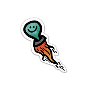 May include: A sticker featuring a teal lightbulb with a smiling face, depicted as a rocket with orange flames and black smoke trails. The sticker has a white border and the text "draftpaper.co" is visible.
