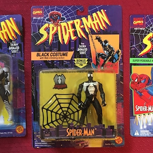 May include: Three unopened action figure packages of Spider-Man from the 1990s. The figures are from the animated series and feature Spider-Man in his classic red and blue suit, a black suit, and a silver suit. Each package includes a bonus collector pin.