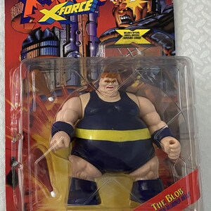 May include: A plastic action figure of The Blob from the X-Men comics. The figure is wearing a blue and yellow costume and has a large, rubbery belly. The figure is packaged in a plastic blister pack with a red and yellow background. The packaging includes the text "The Blob" and "Rubber Blubber Belly".