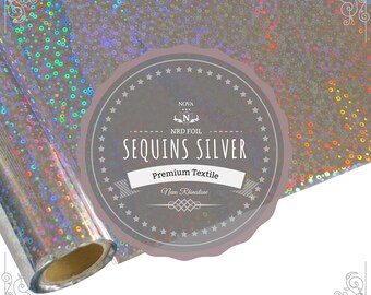 May include: A roll of silver holographic fabric with a label that reads "Nova NRD Foil Sequins Silver Premium Textile Nova Rhinestone".