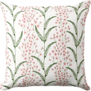May include: A white throw pillow with a floral pattern featuring pink flowers and green leaves.