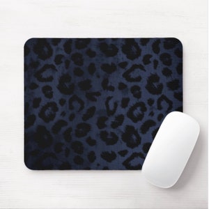 Puede incluir: Una alfombrilla de rat&oacute;n azul oscuro con un dise&ntilde;o de estampado de leopardo negro. La alfombrilla de rat&oacute;n est&aacute; sobre una superficie de madera blanca.