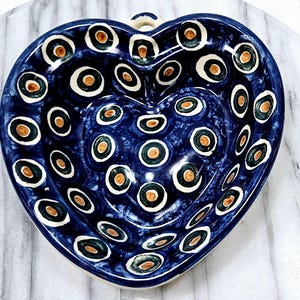 May include: A blue heart-shaped ceramic dish with a white and brown polka dot pattern.