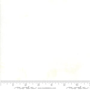 May include: A white fabric with a subtle texture. The fabric is marked with a ruler and the words "moda" and "www.modafabrics.com".