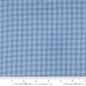 May include: Light blue fabric with a dark blue plaid pattern. The fabric has a grid-like design, with evenly spaced vertical and horizontal lines. The image includes a ruler at the bottom with the text "moda" and "www.modafabrics.com".