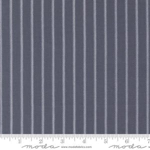 May include: A close-up of a fabric with a dark blue background and vertical white pinstripes. The fabric has a textured appearance. The bottom of the image shows a ruler with inch measurements, equivalent to cm.