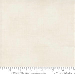 May include: A plain white fabric with a subtle texture. The fabric is a solid colour with no pattern or design. The fabric is shown with a ruler for scale.