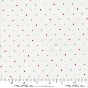 May include: Cream-coloured fabric featuring a repeating pattern of red, blue, and grey polka dots. The dots are evenly spaced. A ruler is at the bottom of the image, with the word "moda" printed on it.