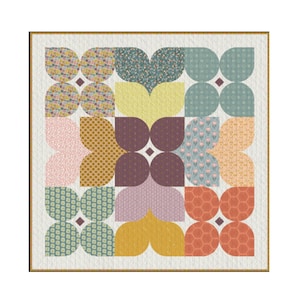 May include: A colorful quilt with a floral pattern. The quilt features a variety of fabrics in shades of pink, yellow, green, and orange, arranged in a symmetrical design. The quilt is bordered with a light brown fabric.