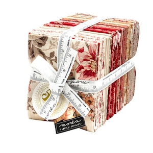 May include: A bundle of fabric squares, patterned with red, cream, and brown floral designs, bound with a white ribbon marked with measurements. A tag reads "moda FABRICS + SUPPLIES!"