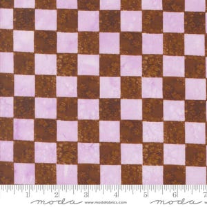 May include: A brown and light purple checkered fabric with a subtle floral pattern. The fabric is shown with a ruler for scale.
