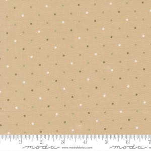 May include: A tan fabric featuring a repeating pattern of small white and olive green polka dots. A white ruler is visible at the bottom edge, showing a measurement scale of 7 inches, with the text moda and www.modafabrics.com printed below.