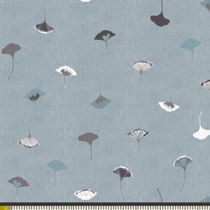 May include: A blue fabric with a repeating pattern of white and gray ginkgo leaves. The fabric is measured in inches.
