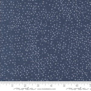 May include: A close-up of a blue fabric with a dotted pattern. The fabric has a grid-like texture with small, light-colored dots scattered across the surface. The fabric is likely cotton or a similar material.