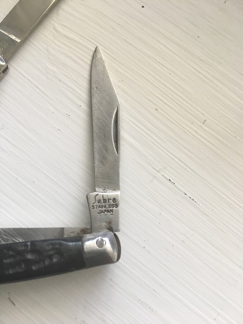 Set of 3 knives Sabre Revlon Pocket Knives and one that is not Marked