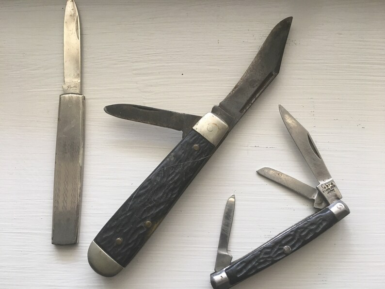 Set of 3 knives Sabre Revlon Pocket Knives and one that is not Marked