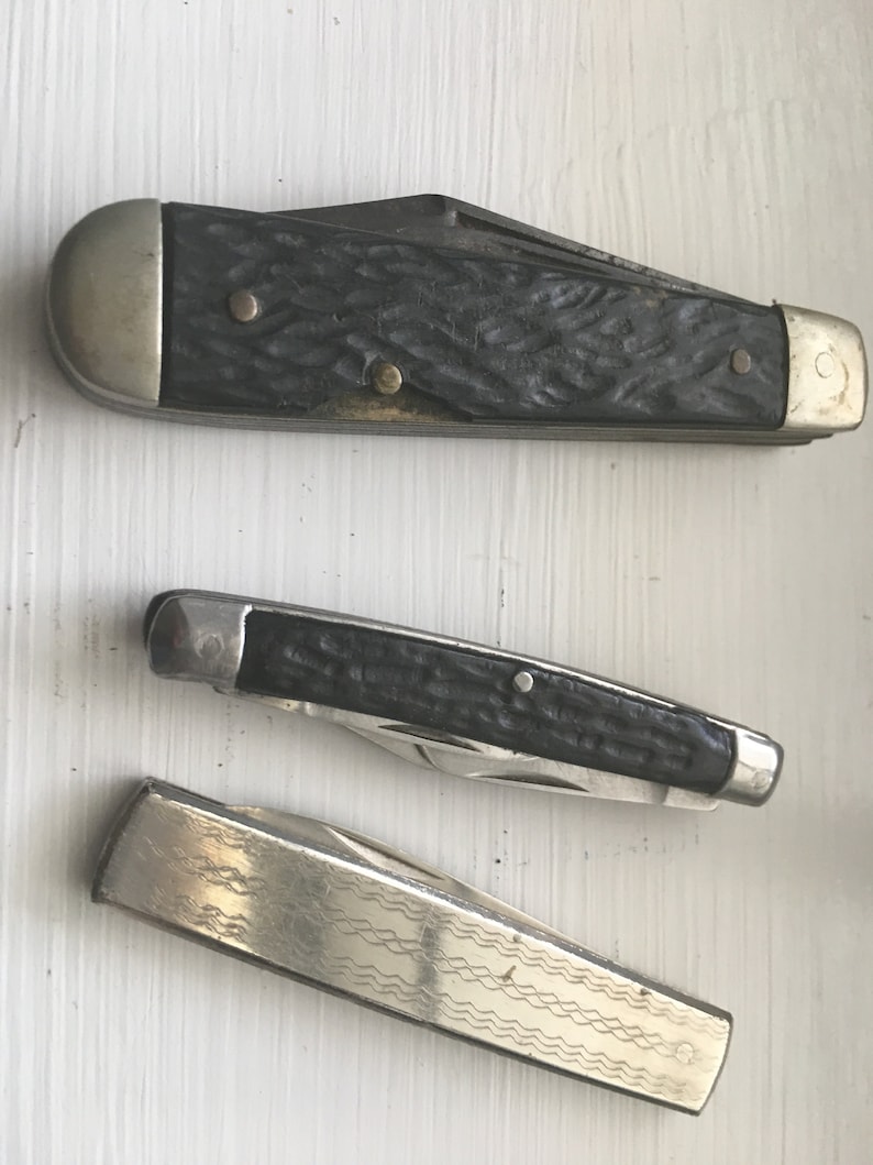 Set of 3 knives Sabre Revlon Pocket Knives and one that is not Marked