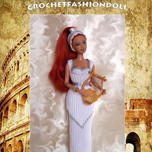 Può includere: Un abito bianco all'uncinetto con dettagli argentati e un cappello bianco all'uncinetto. La bambola tiene una lira di legno. Lo sfondo è un'immagine del Colosseo di Roma. Il testo "ROMA" è nella parte inferiore dell'immagine. Il testo "BY ANNA RITA" è nell'angolo in basso a destra dell'immagine.