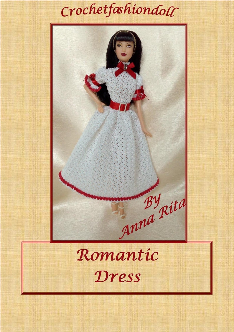 May include: A white crochet dress with red trim and a red belt is displayed on a doll. The dress has short sleeves with red accents and a red bow at the neckline. The text "Romantic Dress" is visible.