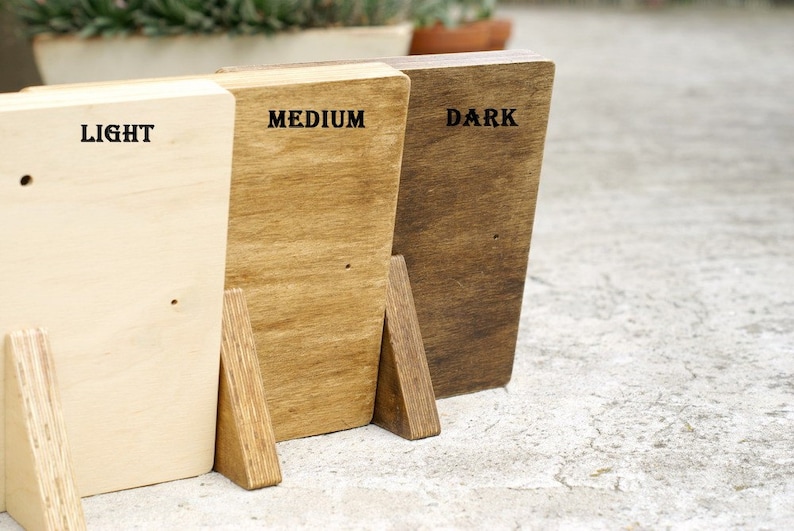 May include: Three wooden blocks, each stained a different shade of brown. The blocks are labeled "LIGHT", "MEDIUM", and "DARK".