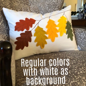 May include: White pillow with a design of brown, yellow, and green felt oak leaves. The text "Regular colors with white as background" is below the pillow.