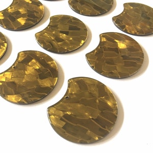 May include: A set of ten gold-colored, half-circle shaped, decorative embellishments with a textured, mosaic-like pattern.