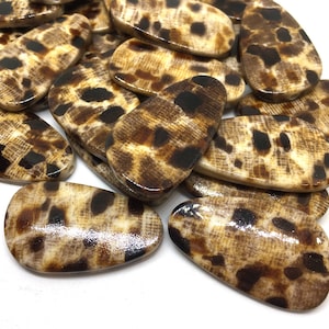 May include: A group of brown and black patterned oval-shaped resin hair clips.