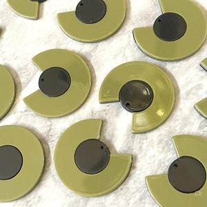 May include: Ten olive green and black semi-circle shaped resin embellishments with a hole in the center.