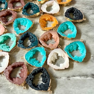 May include: Assortment of agate slice pendants with gold-toned metal accents. The slices are in various colors, including teal, white, black, brown, and orange.