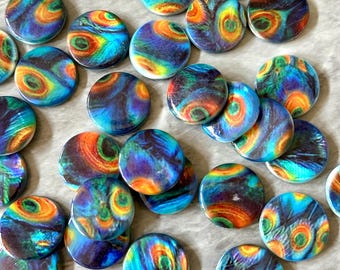 Könnte beinhalten: Eine Sammlung runder, farbenfroher Cabochons mit Pfauenfedermuster. Die Cabochons weisen wirbelnde Muster in Blau, Grün, Orange und Gelb auf. Diese dekorativen Cabochons eignen sich für die Schmuckherstellung, das Basteln oder andere kreative Projekte.