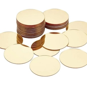 Puede incluir: Una colección de discos circulares dorados. Algunos están apilados, otros dispersos. Los discos tienen una superficie reflectante, lo que sugiere un material metálico. La presentación general es limpia y organizada.