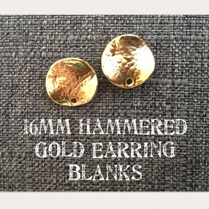 May include: Two 16mm gold hammered earring blanks. The blanks are round and have a hammered texture. They are on a gray fabric background.