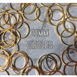 May include: A close-up of a pile of 20mm gold metal circles. The circles are arranged in a random pattern on a gray marble surface. The text "20MM CIRCLES" is printed in black on a white background.