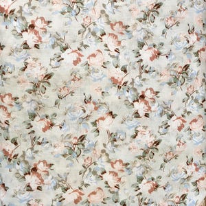 Pode incluir: Um tecido branco com um padrão floral com rosas cor-de-rosa e azuis com folhas verdes.