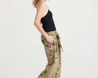 Eva floral linen pants in a stunning rose print in pale olive .