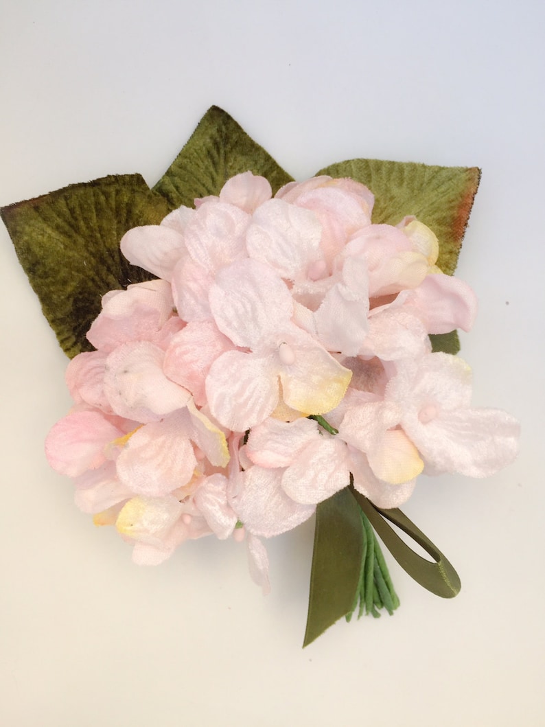 May include: A bouquet of pink velvet hydrangeas with green velvet leaves and a green ribbon.