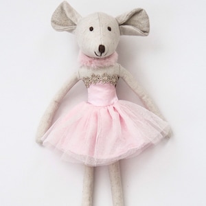 May include: A gray and white fabric mouse doll wearing a pink tulle tutu with gold trim and a white fur collar.