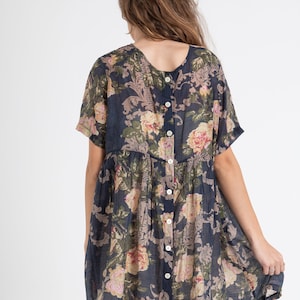 Puede incluir: Un vestido corto de flores azul marino con botones en la espalda. El vestido tiene un corte holgado y mangas cortas.