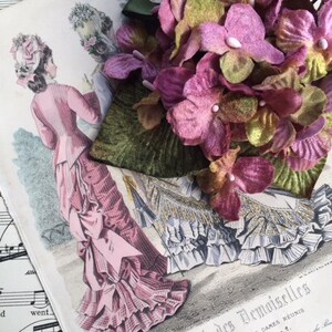 May include: A vintage illustration of two women wearing elaborate dresses, with a large bouquet of pink and green velvet flowers in the foreground. The text "Journal des Demoiselles" is visible at the bottom of the image.