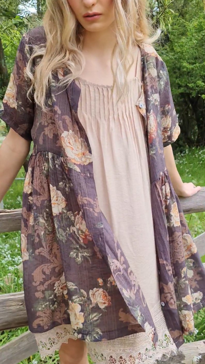 Puede incluir: Un vestido de estampado floral marr&oacute;n con un slip beige debajo. El vestido tiene un borde de encaje y mangas cortas.