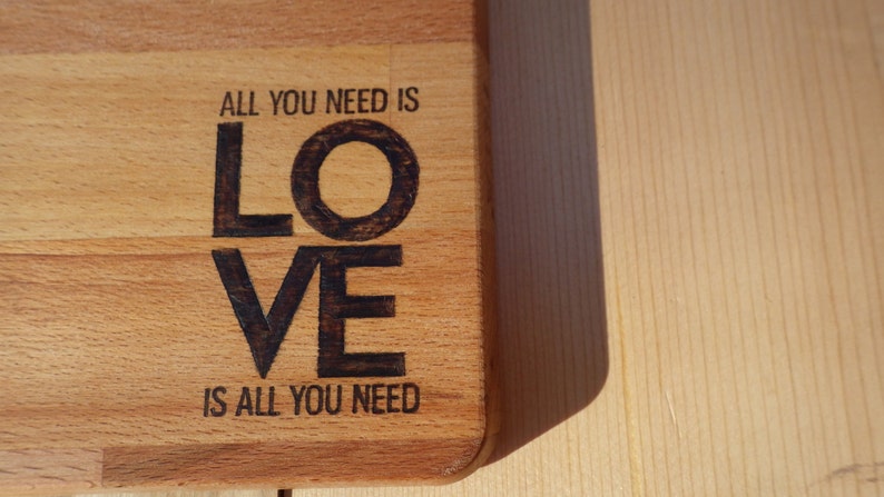 All you need is love Solid Beech Cutting Board with Woodburning Illustration of Classic Saying love is all you need